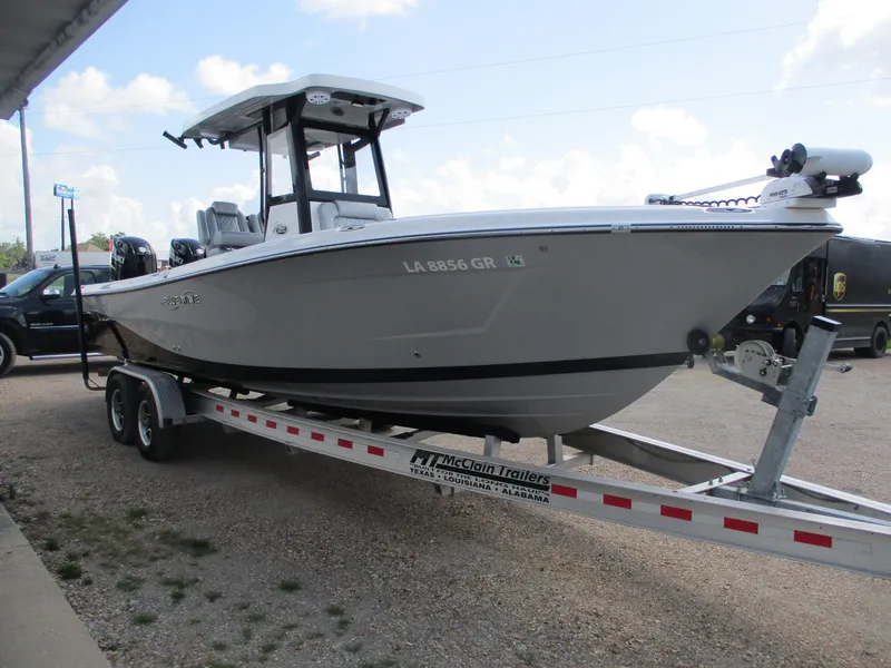 Slide: The Image of 2024 Blue Wave 2800 Makaira boat on trailer, parked outdoors. - 2