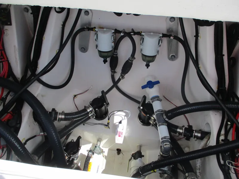 Slide: The Image of Engine compartment of 2024 Blue Wave 2800 Makaira boat, showing hoses and filters. - 20
