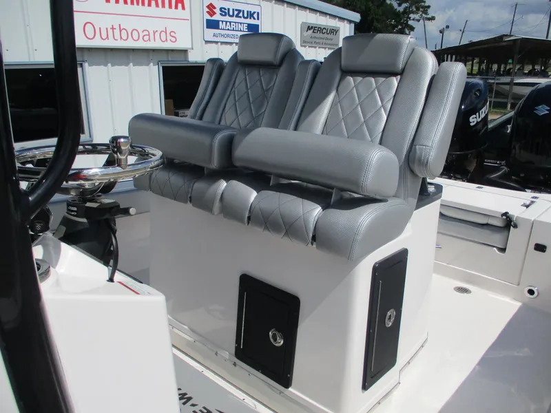 Slide: The Image of 2024 Blue Wave 2800 Makaira boat seats with diamond stitching, near outboard motor signs. - 23