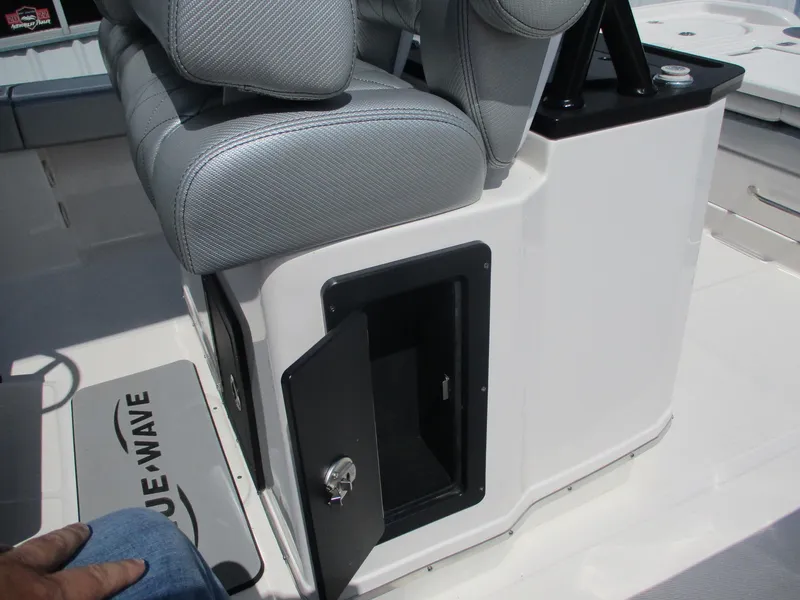 Slide: The Image of 2024 Blue Wave 2800 Makaira boat interior with open storage compartment and cushioned seating. - 24