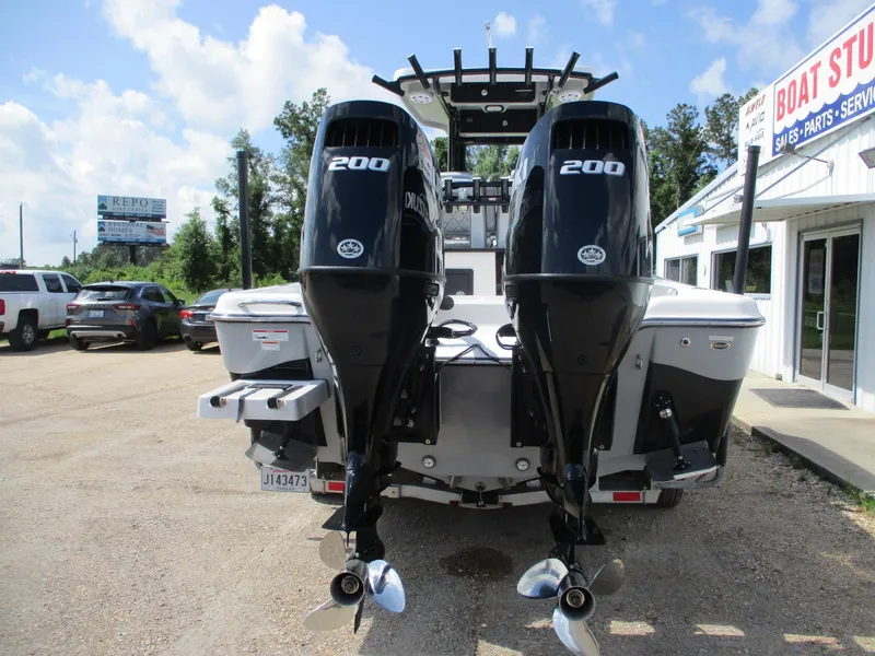 Slide: The Image of 2024 Blue Wave 2800 Makaira boat with dual 200 horsepower engines, parked outside dealership. - 4