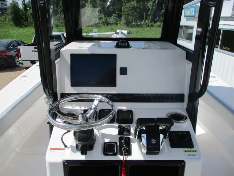 Slide: The Image of 2024 Blue Wave 2800 Makaira boat console with steering wheel and navigation controls. - 9