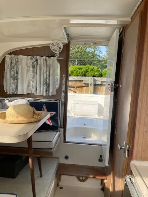 Slide: The Image of Interior of a 1974 Bertram 28 Flybridge boat with open door and seating area. - 13