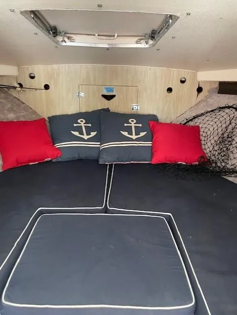 Slide: The Image of Interior of a 1974 Bertram 28 Flybridge with nautical-themed cushions and red pillows. - 14