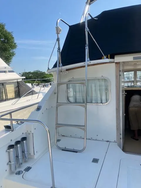 Slide: The Image of 1974 Bertram 28 Flybridge boat with ladder and open cabin door. - 3