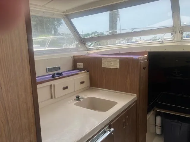 Slide: The Image of 1974 Bertram 28 Flybridge interior with sink and wooden cabinetry. - 4