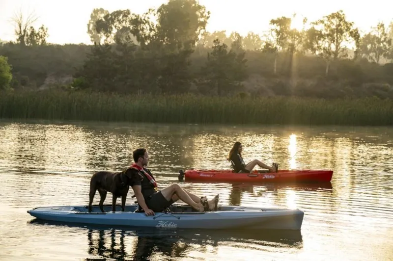 Slide: The Image of Two people kayaking with a dog on Hobie Mirage Outback kayaks, 2025 model, at sunset. - 4