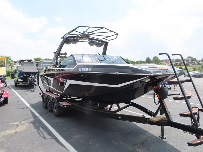 Slide: The Image of 2023 Tigé 24RZX boat on trailer in parking lot, black with white accents. - 4