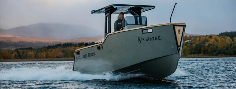 The Image of 2023 X Shore Eelex 8000 electric boat cruising on a scenic lake. - 1