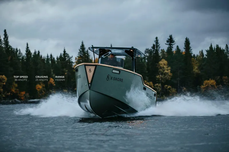 Slide: The Image of 2023 X Shore Eelex 8000 electric boat cruising on a lake with forest backdrop. - 5