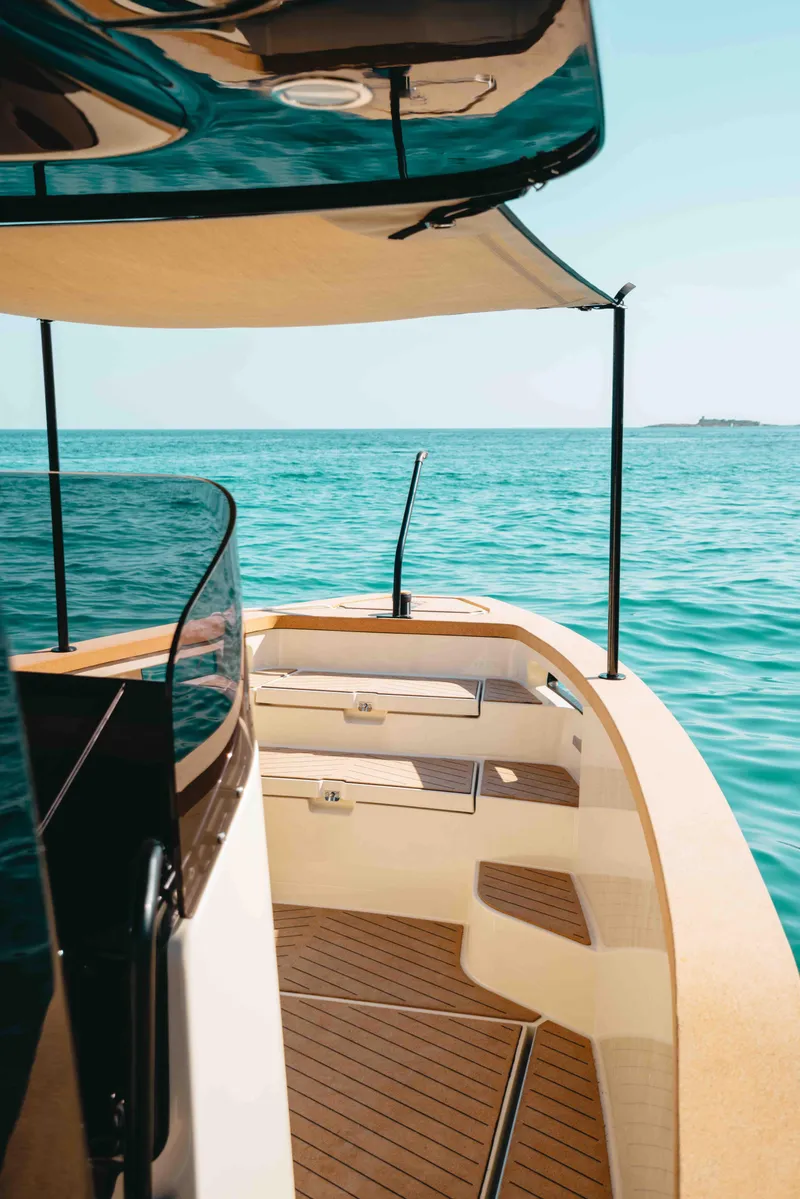 Slide: The Image of 2023 X Shore Eelex 8000 boat on turquoise water, featuring sleek design and wooden deck. - 6