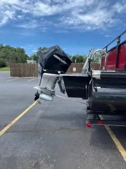 Slide: The Image of 2024 Regency 250 DL3 boat with Mercury outboard motor in parking lot. - 3