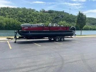 Slide: The Image of 2024 Regency 250 DL3 pontoon boat on trailer by a scenic river. - 4