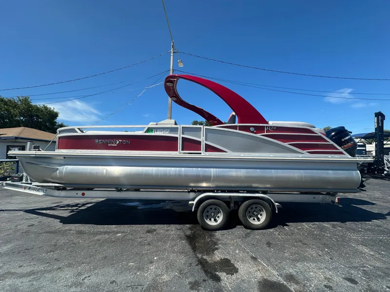 Slide: The Image of 2020 Bennington R 24 RTFBA pontoon boat on trailer, red and silver design. - 14