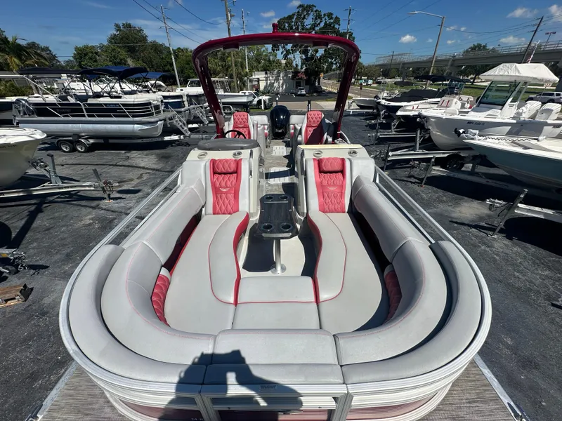 Slide: The Image of 2020 Bennington R 24 RTFBA pontoon boat with red and gray seating, docked outdoors. - 16