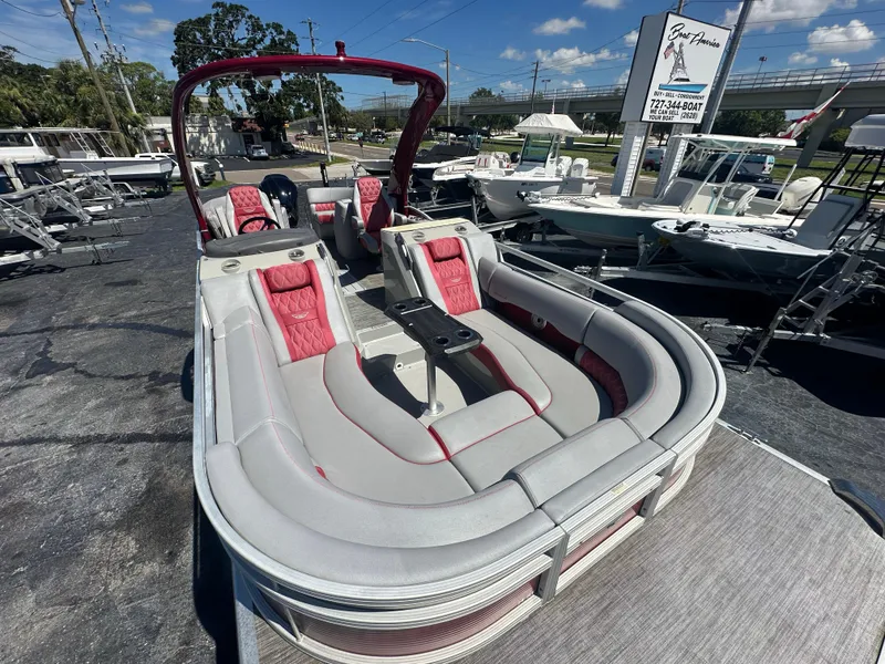 Slide: The Image of 2020 Bennington R 24 RTFBA pontoon boat with red and gray seating, displayed outdoors. - 17