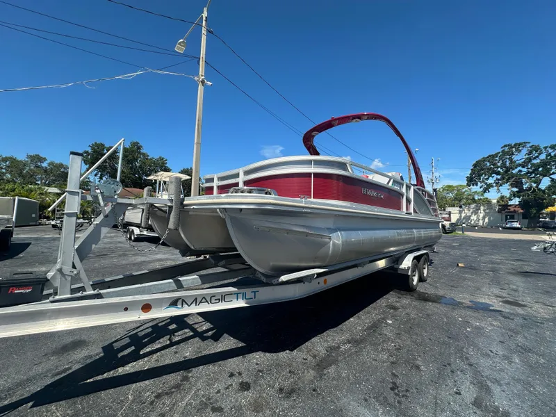 Slide: The Image of 2020 Bennington R 24 RTFBA pontoon boat on trailer, parked outdoors. - 2