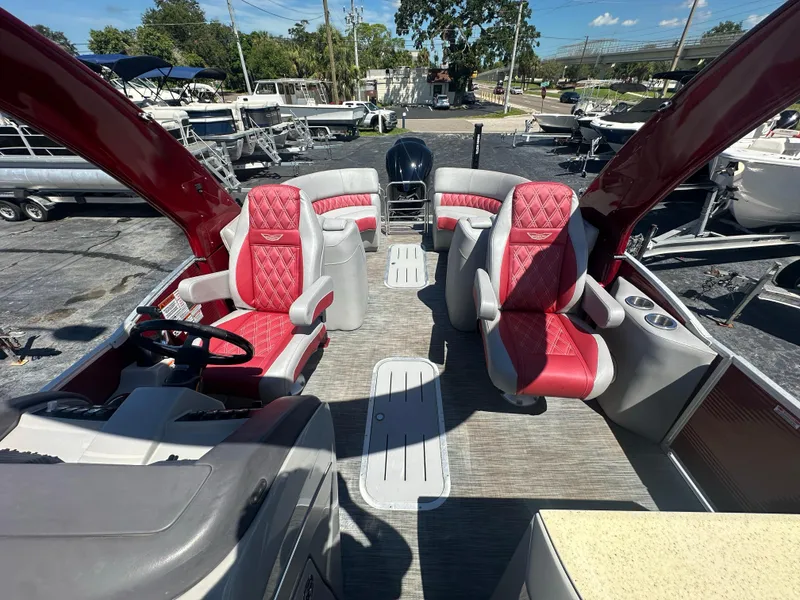 Slide: The Image of 2020 Bennington R 24 RTFBA pontoon boat with red and gray seating, docked outdoors. - 24
