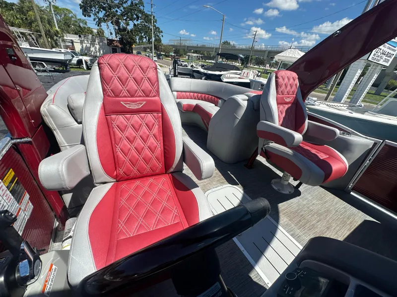 Slide: The Image of 2020 Bennington R 24 RTFBA boat interior with red and gray seating, steering wheel, and controls. - 25