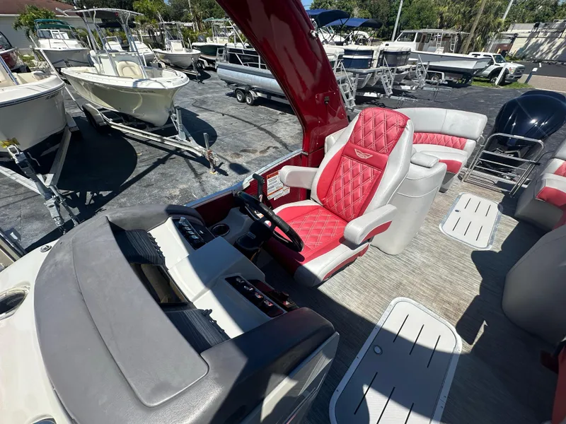 Slide: The Image of 2020 Bennington R 24 RTFBA boat interior with red and white seating, steering wheel, and dashboard. - 26