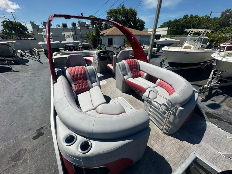 Slide: The Image of 2020 Bennington R 24 RTFBA pontoon boat with red and gray seating, docked outdoors. - 35