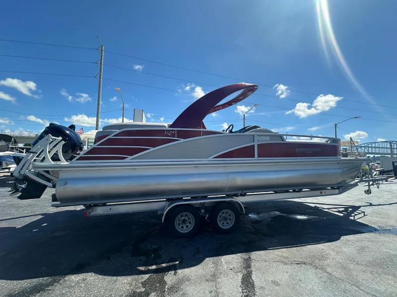 Slide: The Image of 2020 Bennington R 24 RTFBA pontoon boat on trailer under clear blue sky. - 5