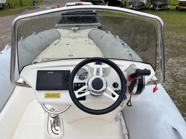 Slide: The Image of 2023 Zodiac NZO-680 boat dashboard with steering wheel and navigation equipment. - 13