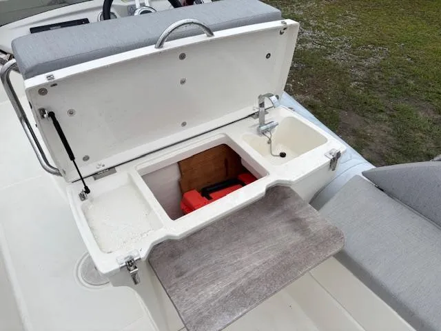 Slide: The Image of 2023 Zodiac NZO-680 boat storage compartment with open lid and visible interior features. - 18