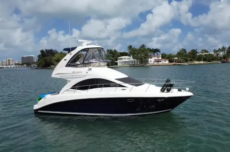 Slide: The Image of 2007 Sea Ray 360 Sedan yacht on calm water, with a scenic coastal backdrop. - 12