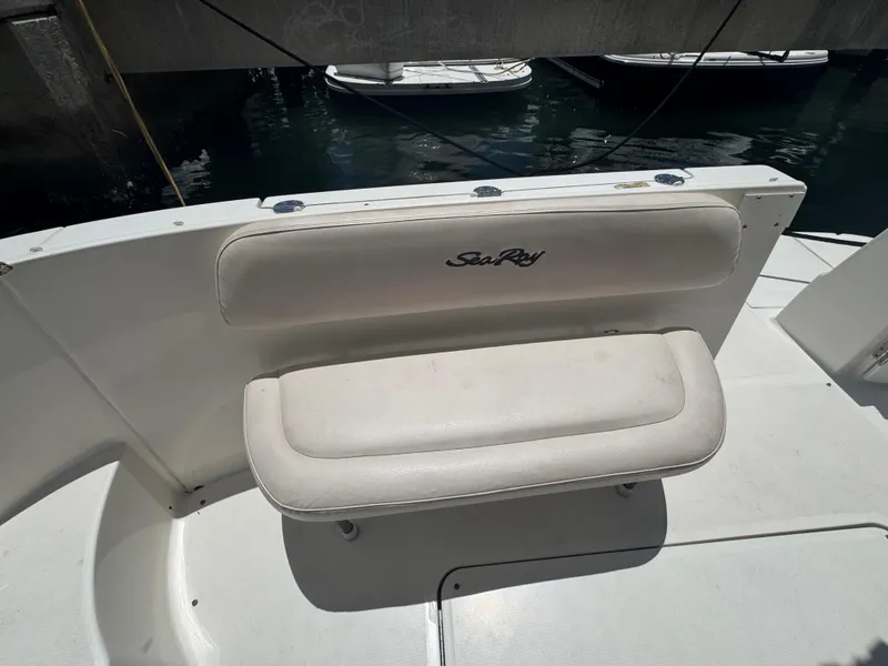 Slide: The Image of 2007 Sea Ray 360 Sedan boat seating area with logo, docked by the water. - 16