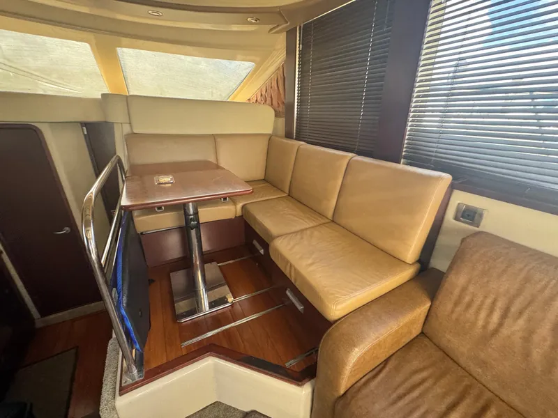 Slide: The Image of Interior of 2007 Sea Ray 360 Sedan with beige seating and wooden table. - 24