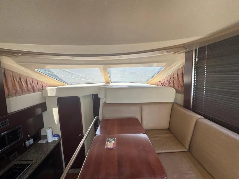 Slide: The Image of Interior of 2007 Sea Ray 360 Sedan with beige seating and wooden table. - 25