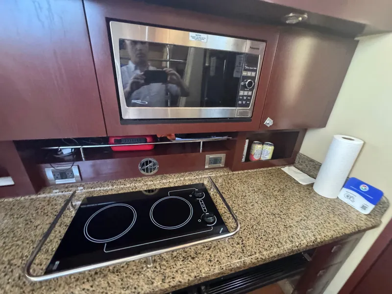 Slide: The Image of 2007 Sea Ray 360 Sedan kitchen with microwave, electric stove, and granite countertop. - 31
