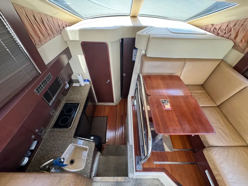 Slide: The Image of 2007 Sea Ray 360 Sedan interior with kitchen, seating, and wooden table. - 43