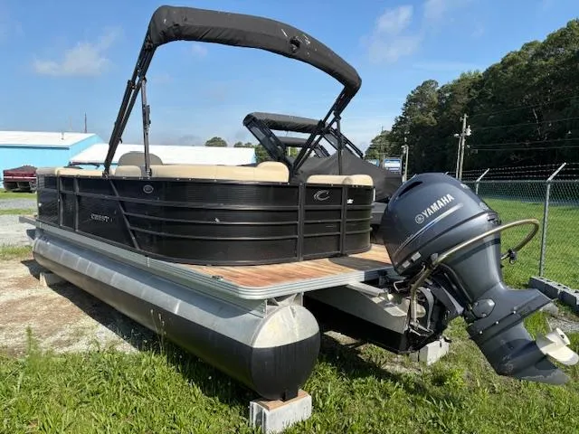Slide: The Image of 2018 Crest I 220 SLC pontoon boat with Yamaha motor on grass near fence. - 2