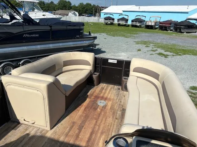 Slide: The Image of 2018 Crest I 220 SLC pontoon boat with beige seating and wooden deck. - 6