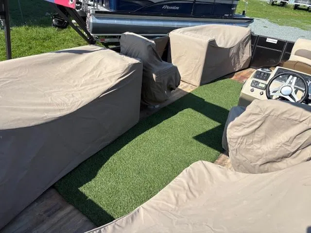 Slide: The Image of 2018 Crest I 220 SLC boat interior with covered seats and artificial grass flooring. - 7