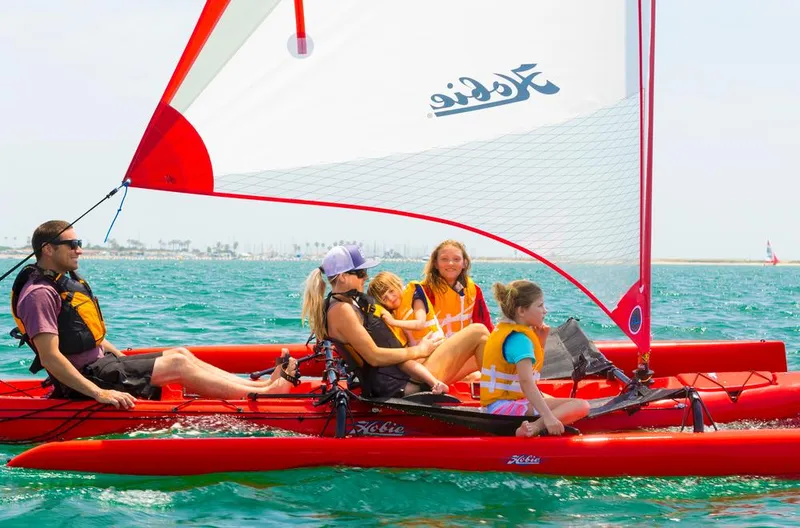 Slide: The Image of Family enjoying sailing on a 2025 Hobie Mirage Tandem Island in sunny waters. - 7