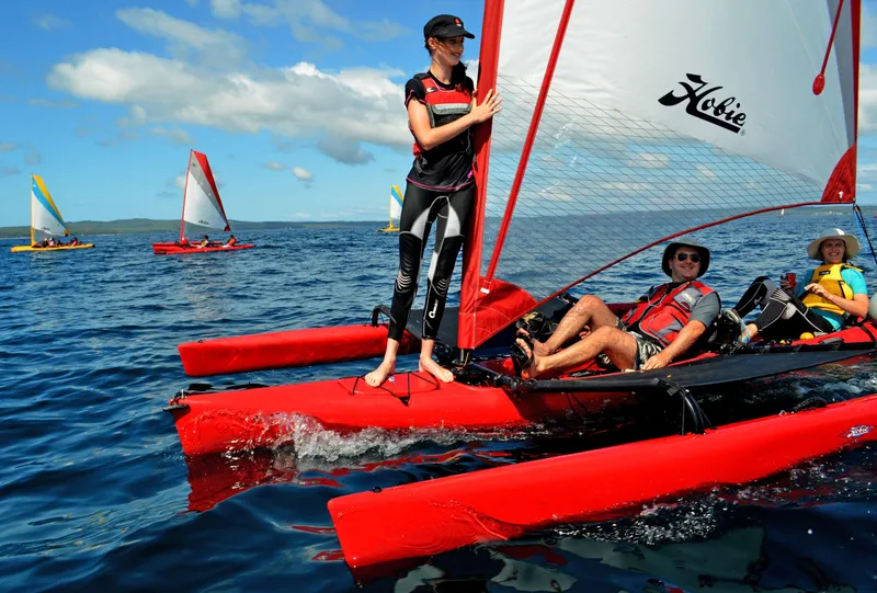 Slide: The Image of 2025 Hobie Mirage Tandem Island sailing on open water with multiple passengers. - 8