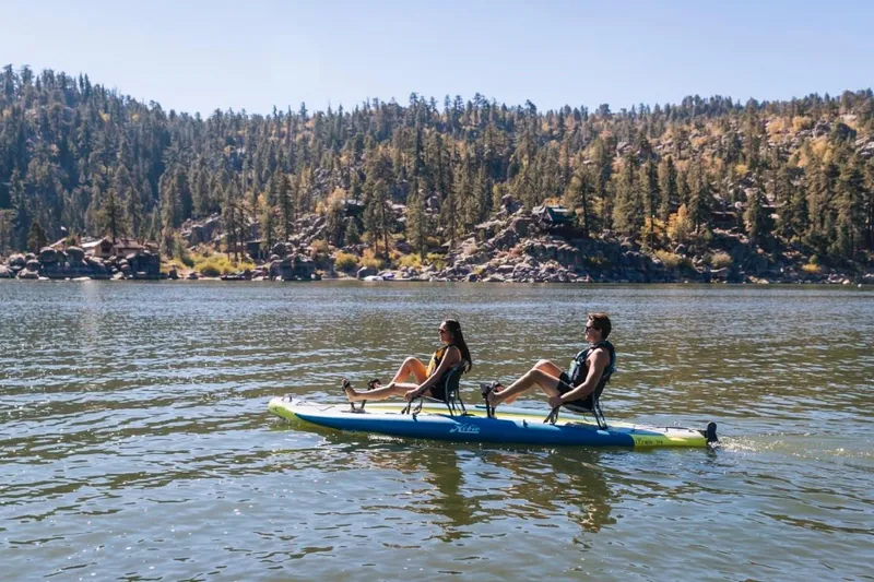 Slide: The Image of Two people kayaking on a 2025 Hobie iTrek 14 Duo in a scenic lake. - 3