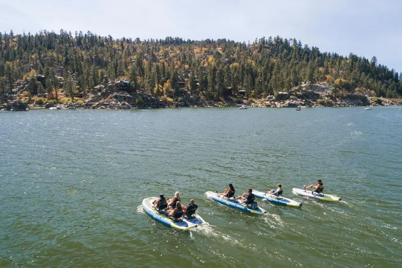 Slide: The Image of People enjoying a lake on Hobie iTrek Fiesta kayaks, surrounded by forested hills. - 5