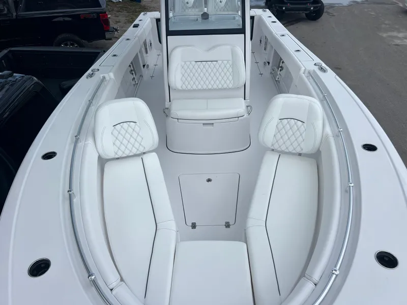 Slide: The Image of 2025 Sportsman Open 262 Center Console boat with white cushioned seating and sleek design. - 17