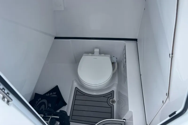 Slide: The Image of 2025 Sportsman Open 262 Center Console boat interior with toilet. - 23