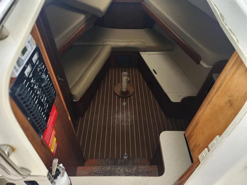 Slide: The Image of 2003 Luhrs 30 Open cabin interior with wood flooring and cushioned seating. - 16