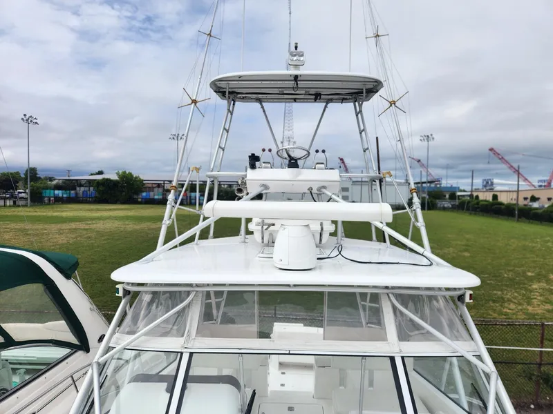 Slide: The Image of 2003 Luhrs 30 Open boat with tower, docked in a marina under cloudy skies. - 6