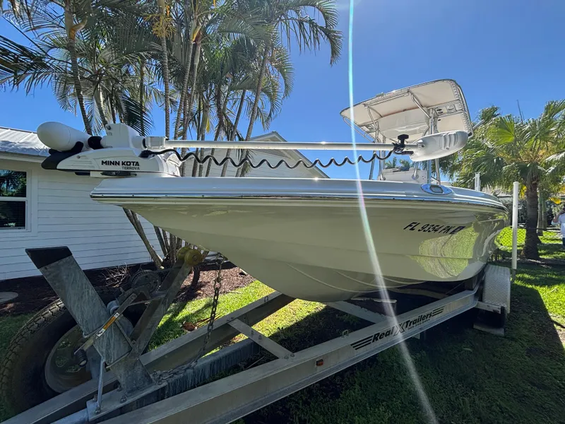 Slide: The Image of 2013 SeaHunter 24 Bay boat on trailer, parked outdoors under clear blue sky. - 10