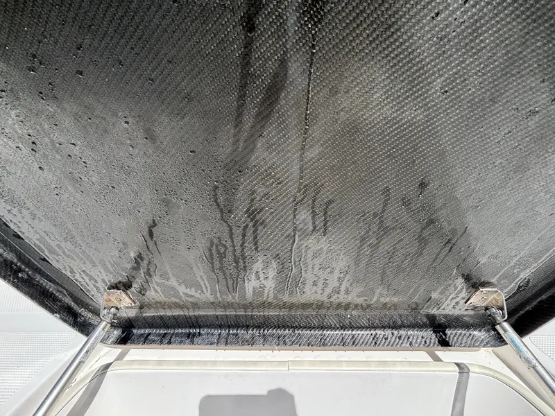 Slide: The Image of 2013 SeaHunter 24 Bay boat canopy with visible water stains and metal supports. - 23