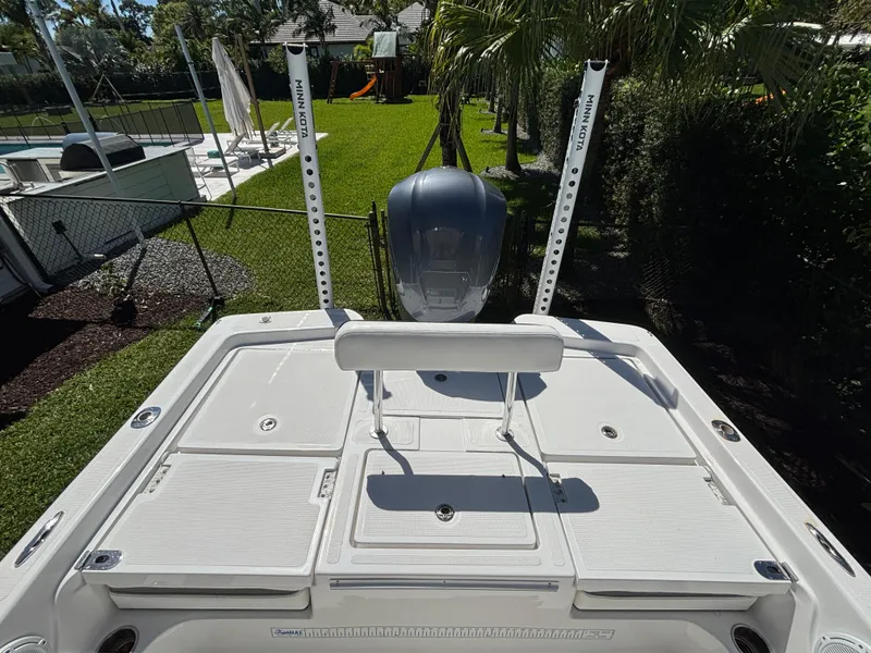 Slide: The Image of 2013 SeaHunter 24 Bay boat with dual power poles and outboard motor, docked in a backyard. - 28