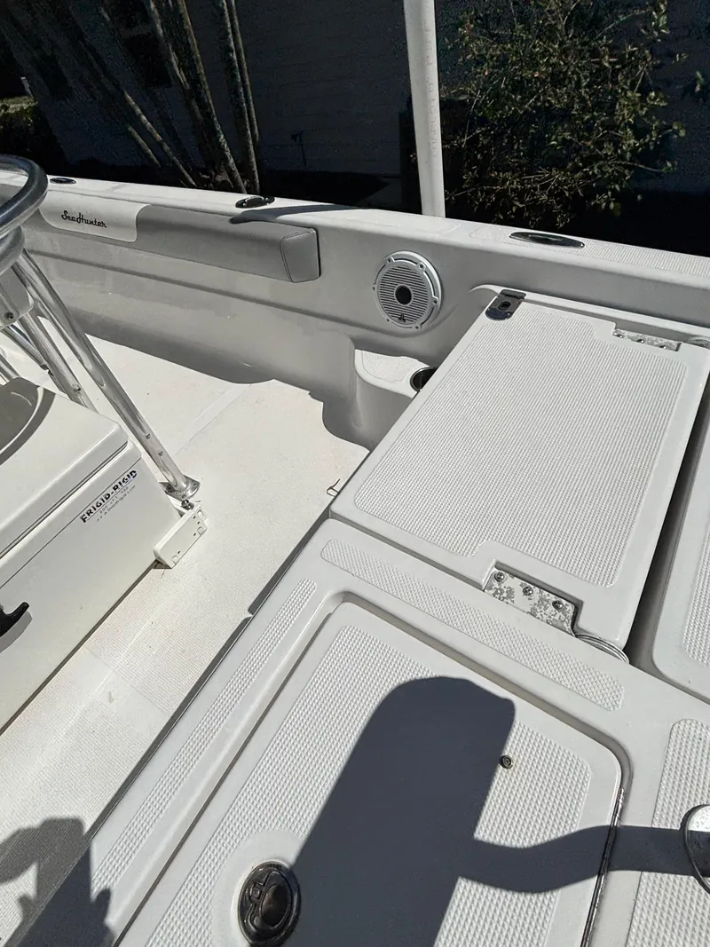 Slide: The Image of 2013 SeaHunter 24 Bay boat deck with storage compartments and seating area. - 34
