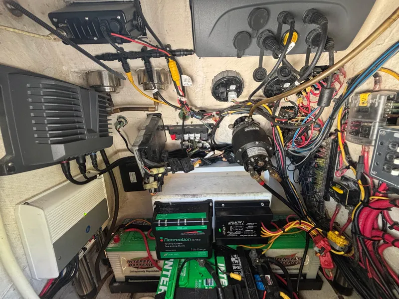 Slide: The Image of Electrical system inside a 2013 SeaHunter 24 Bay boat, featuring batteries and wiring. - 36
